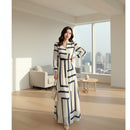 Woman wearing a long, patterned dress on a white background