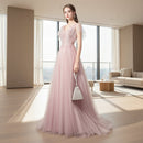 Woman in a pink evening gown against a textured gray wall