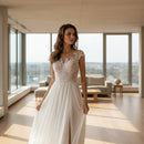 Woman in a white wedding dress with a high slit standing on a beach.