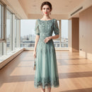 Woman wearing a light blue lace dress against a gray background