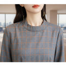 Close-up of a gray and orange checkered fabric on a mannequin