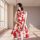 Woman wearing a red and white floral dress against a white background